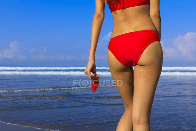 Asiatique fille sur une plage en bikini avec une crème glacée dans sa main
. — Photo de stock