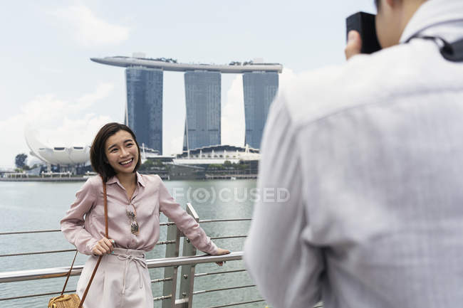 Hombre tomando fotografía de mujer en Singapur - foto de stock
