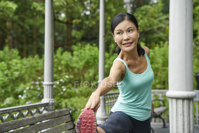 Middle-aged woman warming up in Botanic Gardens before her run — Stock Photo