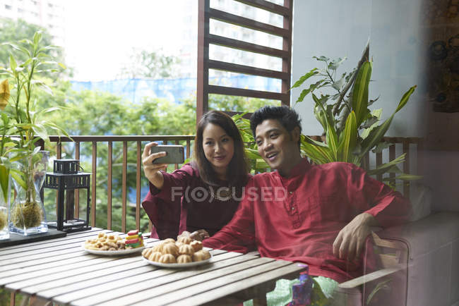 Giovane coppia asiatica che celebra Hari Raya a Singapore e si fa selfie — Foto stock