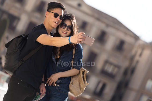 Beautiful young asian couple spending holiday in Barcelona and taking selfie — Stock Photo