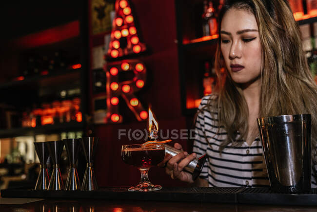 Retrato de una joven camarera haciendo cóctel en el bar - foto de stock