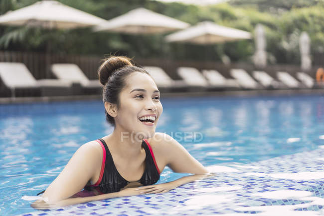 Joven hermosa mujer asiática en traje de baño divertirse en la piscina - foto de stock
