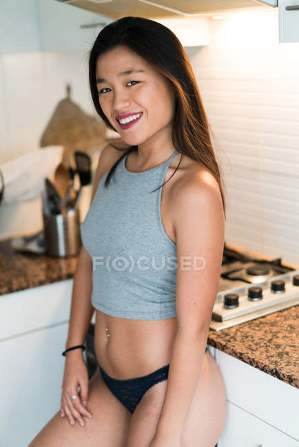 Jeune attrayant asiatique femme en lingerie à cuisine — Photo de stock