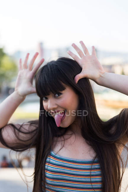 Молодая азиатка делает смешные лица перед камерой — стоковое фото