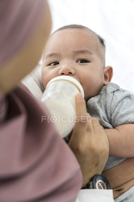 Closeup view of mother feeding milk to her baby. — Stock Photo
