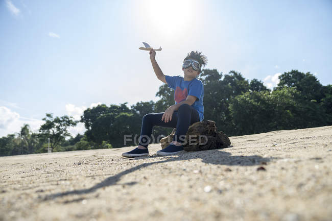 Bambino supereroe che gioca con un aeroplano giocattolo — Foto stock