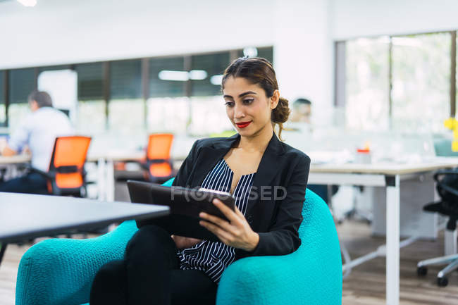 Молодая азиатская деловая женщина с планшетом в современном офисе — стоковое фото
