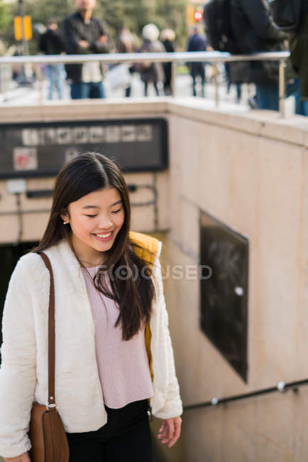 Joven mujer china saliendo del metro de barcelona, yendo a las calles de Cataluña - foto de stock