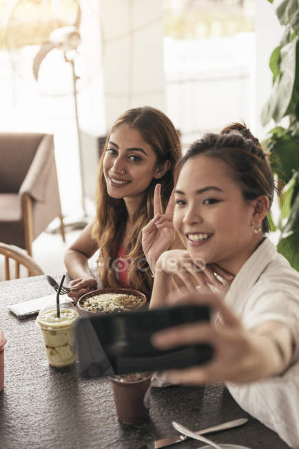 Two young beautiful asian women spending time in cafe — Stock Photo