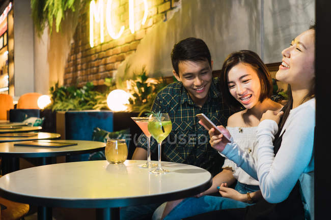 Young asian friends in comfortable bar — Stock Photo