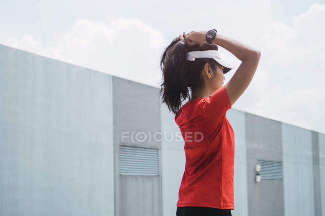 Joven asiático deportivo mujer tocando cabello - foto de stock