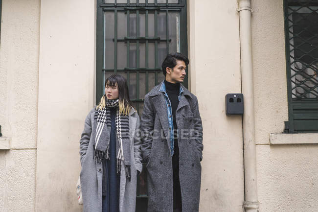 Young attractive casual asian couple posing against building — Stock Photo
