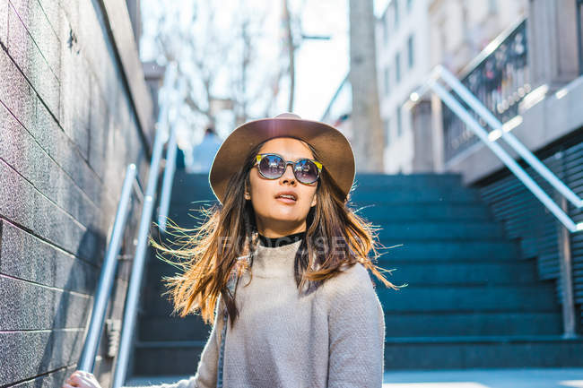 Jeune femme asiatique à lunettes voyageant et marchant sur les escaliers — Photo de stock