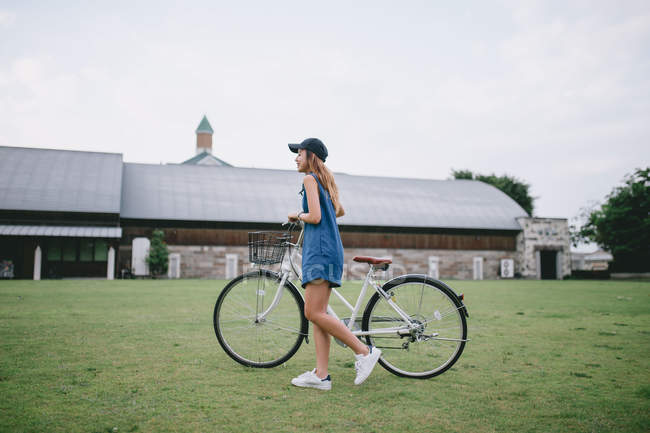 Young woman chilling with her bicycle in Japan — Stock Photo