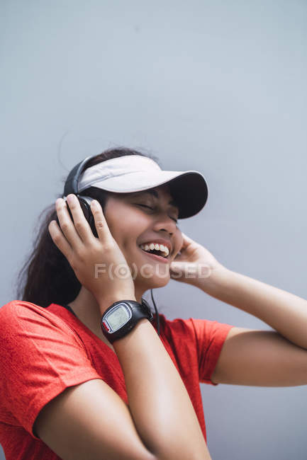 Young asian sporty woman using headphones — Stock Photo