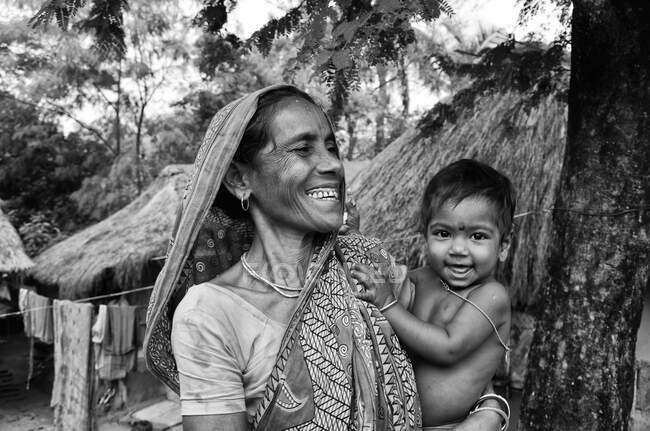 Жінка стоїть зі своїм онуком, коли я проходив через їхнє село. — стокове фото