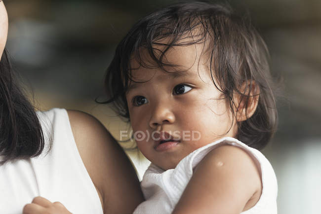 Porträt eines kleinen asiatischen Mädchens auf den Händen der Mutter — Stockfoto