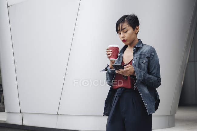 Junge malaiische Singaporeanerin vergnügt sich mit einer Tasse Kaffee im Freien. — Stockfoto