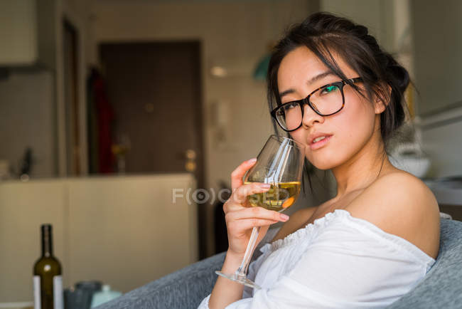 Junge Chinesin trinkt Wein und trägt Gläser — Stockfoto