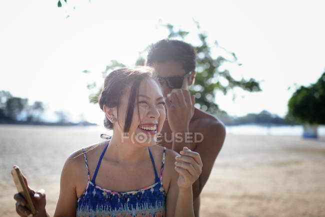 Jovem atraente asiático casal se divertindo na praia — Fotografia de Stock