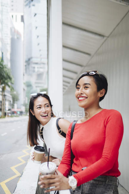 Young asian female friends with coffee cups — Stock Photo