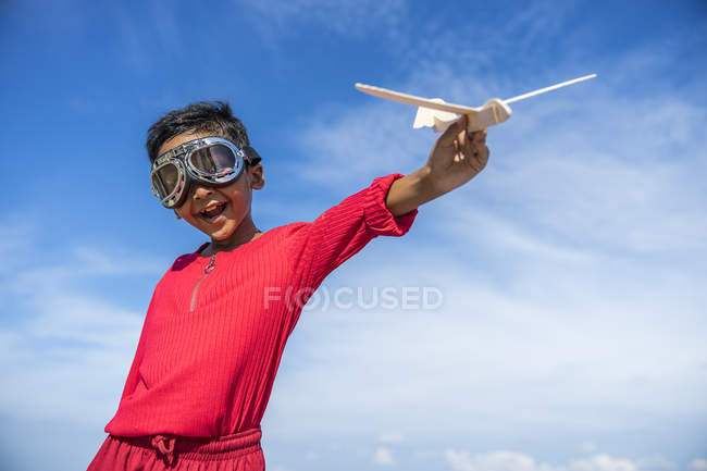 Un niño jugando con un avión de juguete . - foto de stock