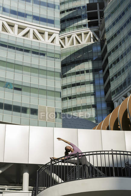 Молоді азіатські жінки розтягування перед її щоденний занедбаному тренування в місті Singapores. — стокове фото