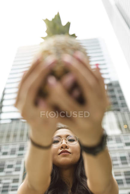 Китаянка показывает ананас в камеру — стоковое фото
