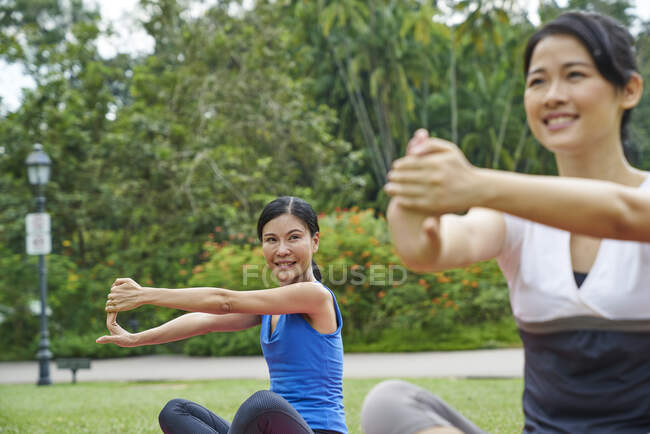 Zwei Frauen praktizieren Yoga im Botanischen Garten in Singapur — Stockfoto
