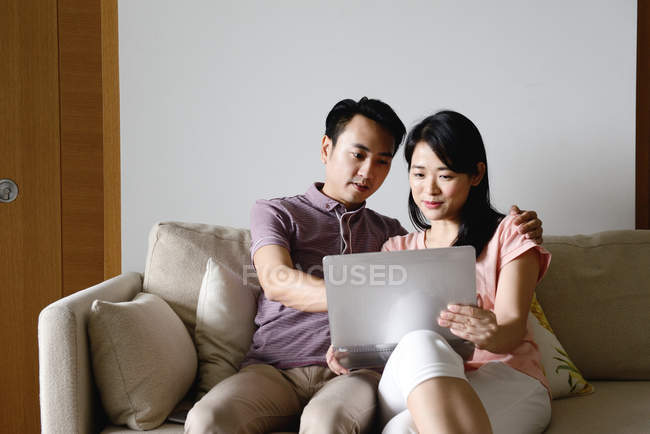 Maduro asiático casual casal usando laptop em casa — Fotografia de Stock