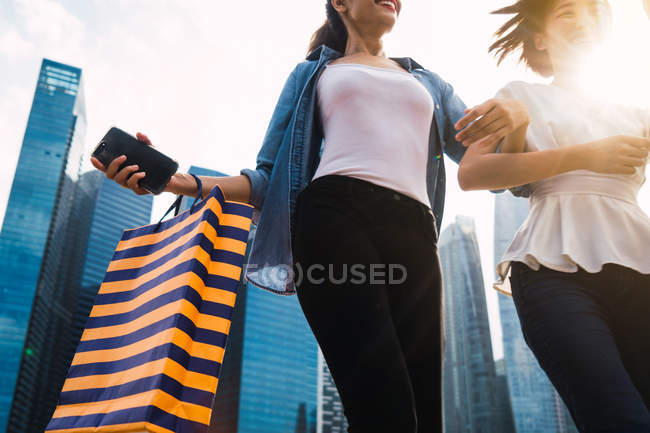 Jeunes belles femmes asiatiques avec des sacs à provisions ensemble dans la ville urbaine — Photo de stock