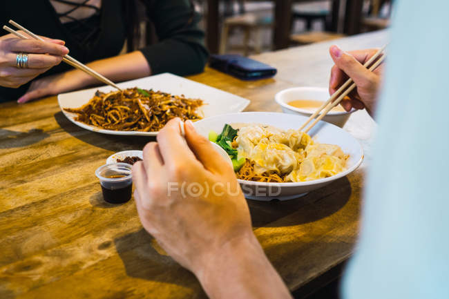 Cropped image of couple eating food in cafe — Stock Photo