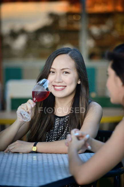 Joven atractivo asiático mujeres teniendo beber juntos - foto de stock