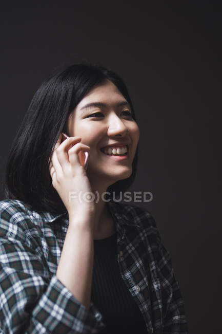 Young beautiful asian girl in casual clothes using smartphone on city streets — Stock Photo