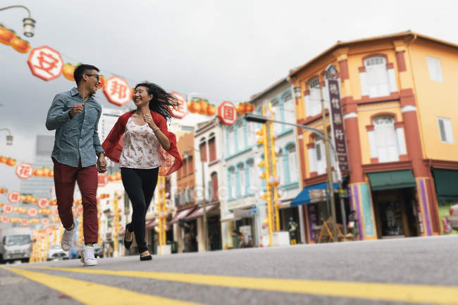 Asiatico Cinese coppia running su strada a Chinatown — Foto stock