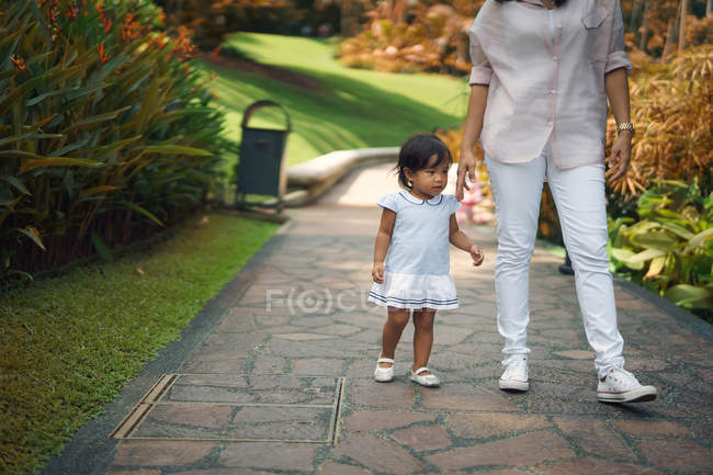 Cute asian mother and daughter walking in park together — Stock Photo