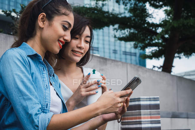 Junge schöne asiatische Frauen zusammen in urbaner Stadt per Smartphone — Stockfoto