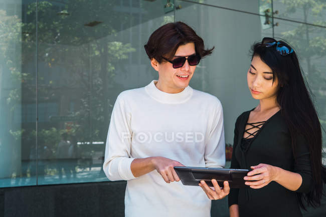 Jovem asiático casal compartilhamento digital tablet — Fotografia de Stock