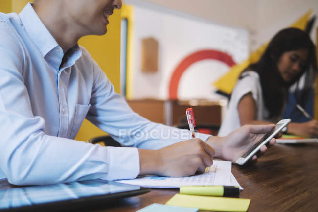 Young asian man working in creative modern office — Stock Photo