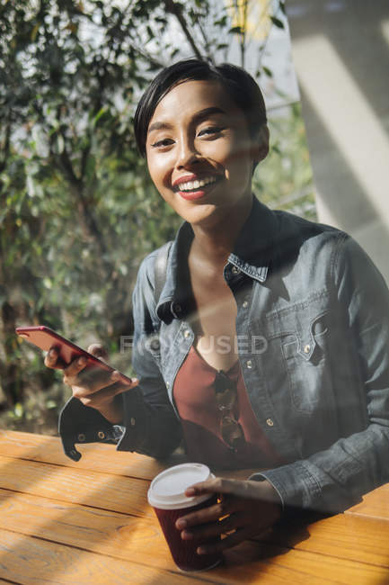Портрети молода леді сінгапурських Малайська, насолоджуючись себе з її телефон за межами. — стокове фото