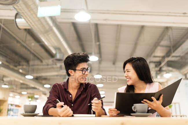 Des collègues asiatiques discutent d'un projet dans un bureau moderne — Photo de stock