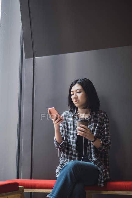 Jovem bela menina asiática em roupas casuais usando smartphone nas ruas da cidade — Fotografia de Stock