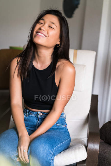 Jeune attrayant asiatique femme assis sur fauteuil — Photo de stock
