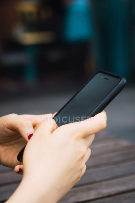 Обрезанное изображение женских рук со смартфоном — стоковое фото