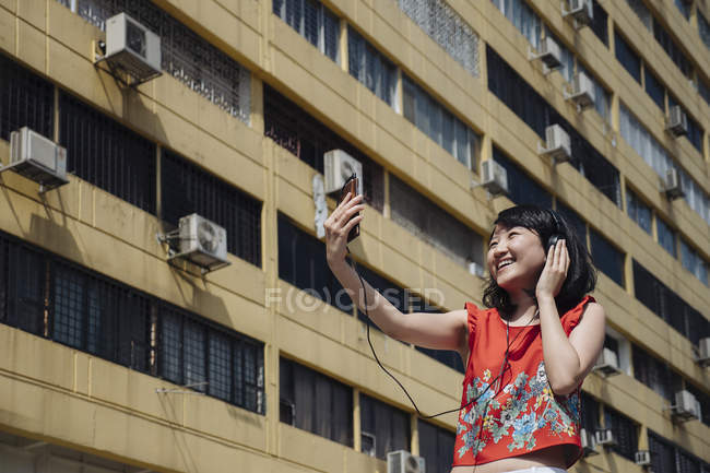 Asian tourist woman taking selfie against building — Stock Photo