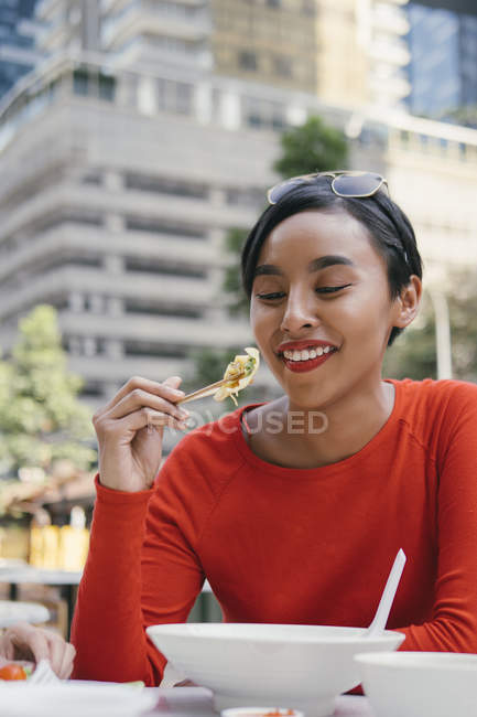 Молода азіатська приваблива жінка їсть на продовольчому корті — стокове фото