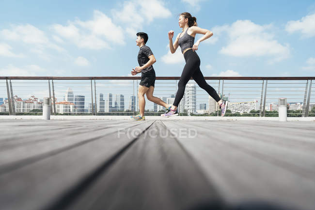 Asiático casal correndo ao ar livre — Fotografia de Stock