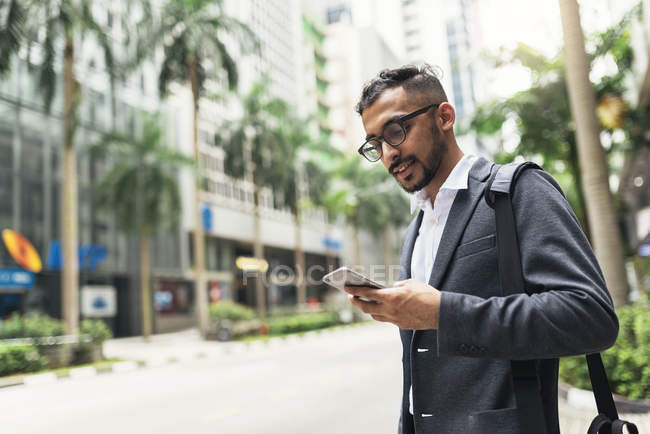 Joven empresario exitoso utilizando el teléfono inteligente - foto de stock