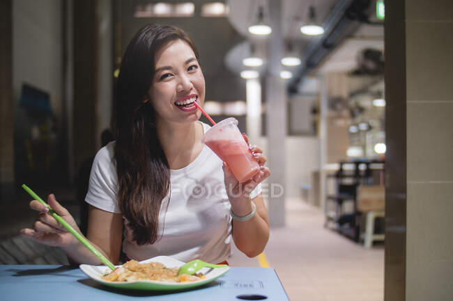 Азійка їсть місцеву їжу. — стокове фото